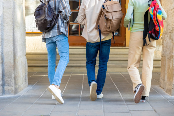 Students students walking backwards to camera after university classes